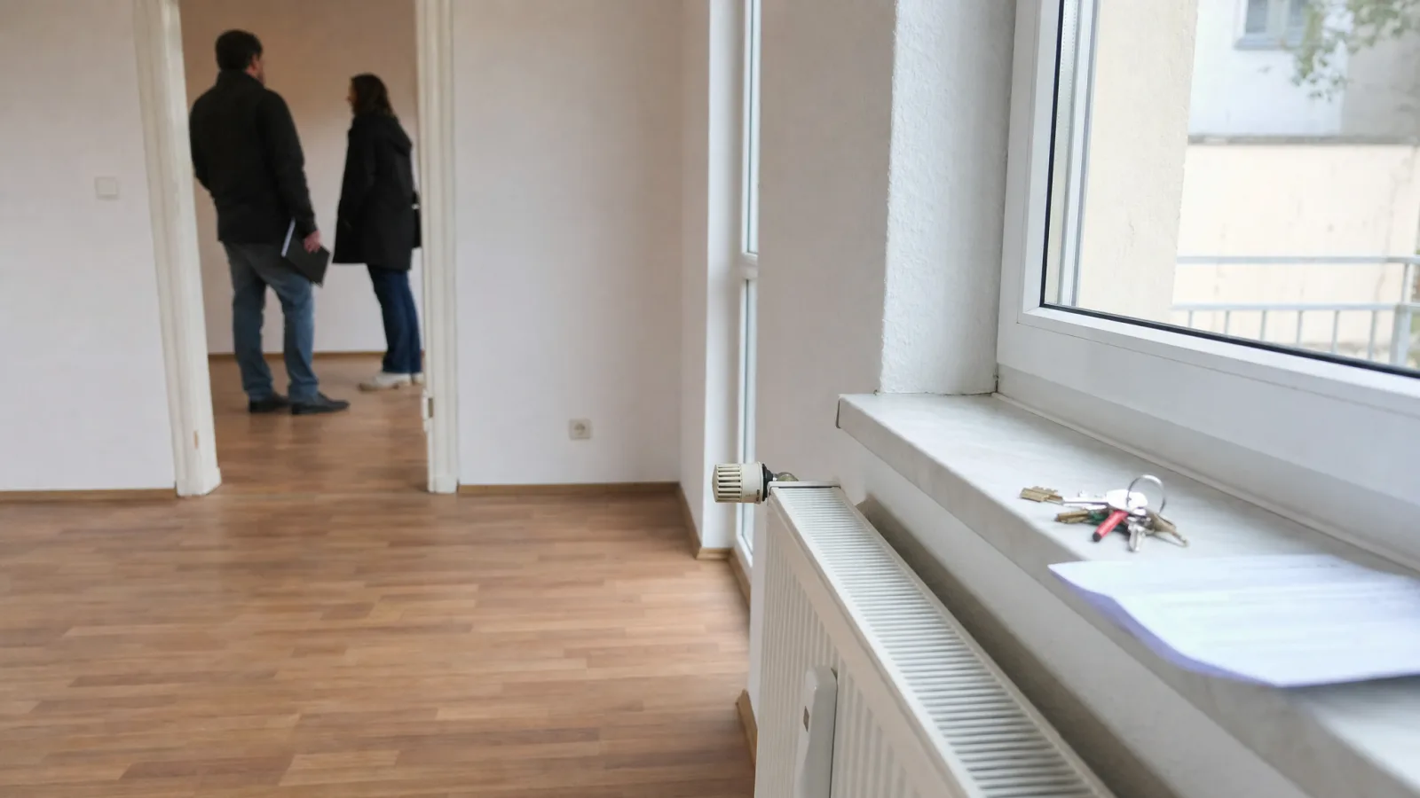 Wohnungsübergabe: Schlüssel auf der Fensterbank einer leeren, frisch gestrichenen Wohnung