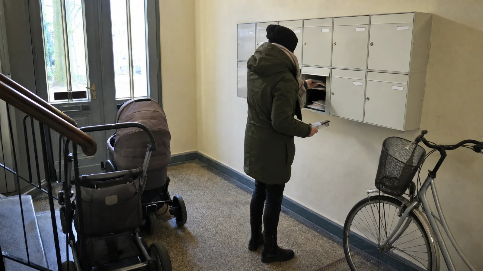 Post wird aus dem Briefkasten im Hauseingang genommen