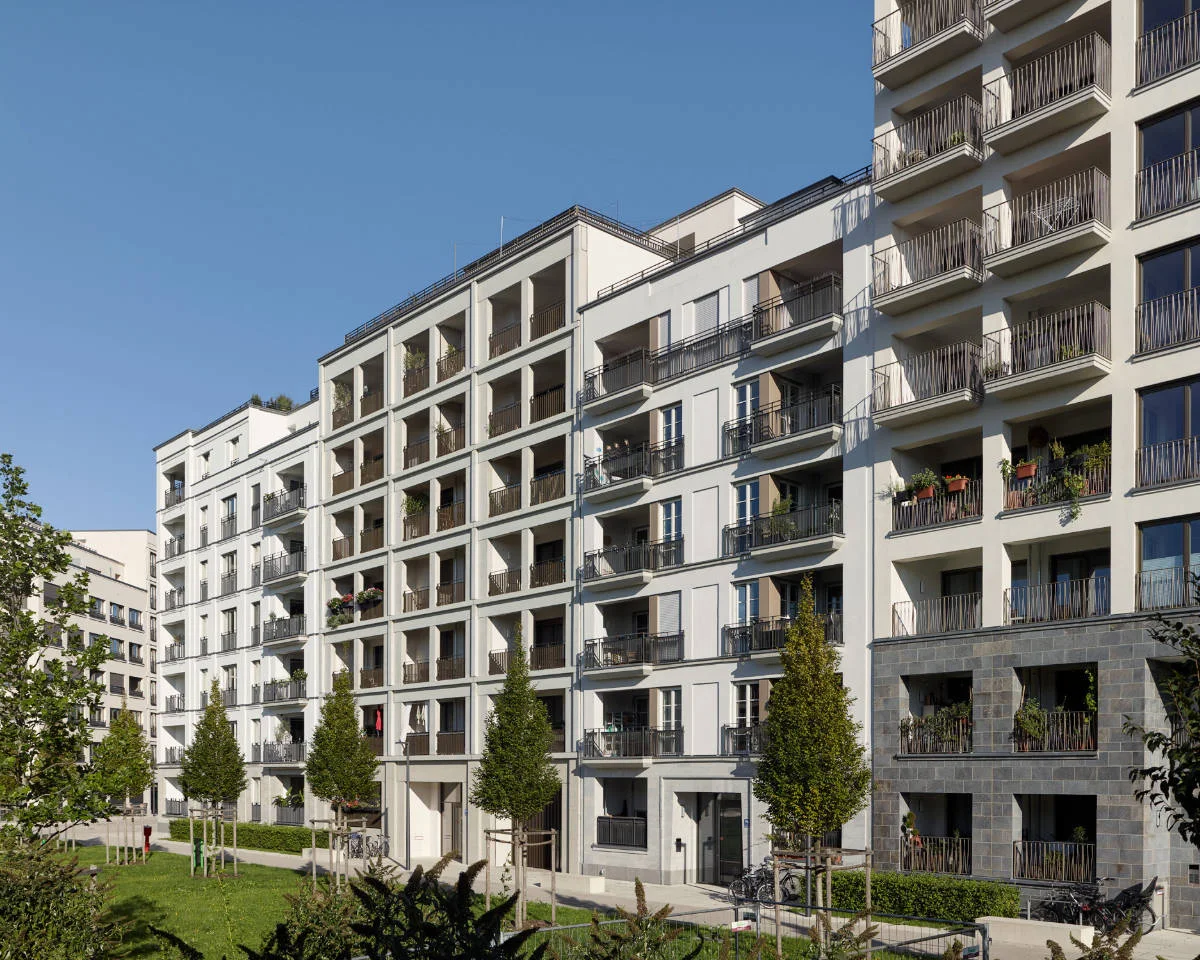 Moderner Wohnblock mit Balkonen und begrüntem Vorplatz in München